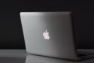 Dragon for Mac blog: Grey Apple Mac laptop on a desk with a dark background.